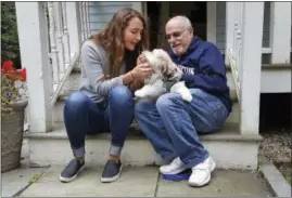  ??  ?? In this photo provided by the Boston Symphony Orchestra, Grace Ellrodt, left, and conductor David Zinman sit with Zinman’s puppy Carlito outside his home Monday in Lenox, Mass.