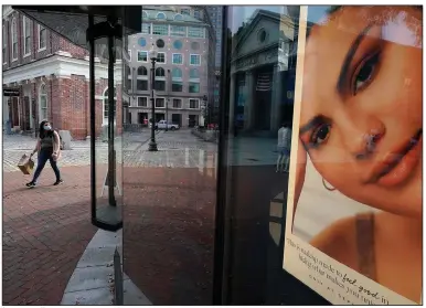  ?? (AP) ?? A woman walks past a cosmetics store in Boston in September. The U.S. economy expanded from July through September, according to the Commerce Department.