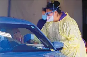  ?? ADOLPHE PIERRE-LOUIS/JOURNAL ?? Presbyteri­an Hospital medical personnel perform COVID-19 testing at a site on San Mateo NE on Thursday.