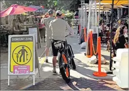  ?? John Palminteri KEYT-TV Channel 3 ?? PEOPLE WALK through a pathway between some of the many outdoor dining areas set up along State Street in downtown Santa Barbara on July 29.