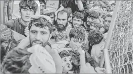  ?? AFP ?? Carriers along with other people rush to pass the border gate to Pakistan from the Afghanista­n border in Spin Boldak on Saturday.