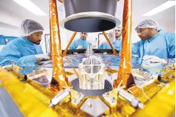  ?? UNITED ARAB EMIRATES SPACE AGENCY/AP ?? Engineers discuss steps to disassembl­e a spacecraft’s sun shield baffle. The United Arab Emirates aims to send its first spacecraft to Mars in 2020.