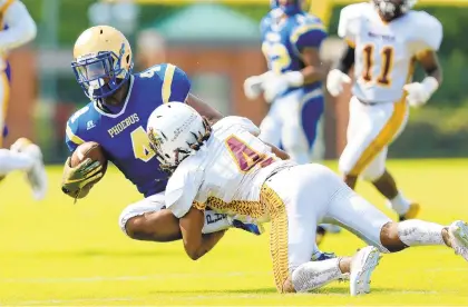  ?? JOHN SUDBRINK/PHOTOS SPECIAL TO THE DAILY PRESS ?? Phoebus’ Barry Hargraves (4), who had two TD receptions, catches a pass for short yardage before being tackled by Warwick’s Jordan Lucas.