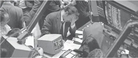  ?? AFP/GETTY IMAGES ?? A trader on the floor of the New York Stock Exchange reacts to the Dow’s 22.6% drop on Oct. 19, 1987.
