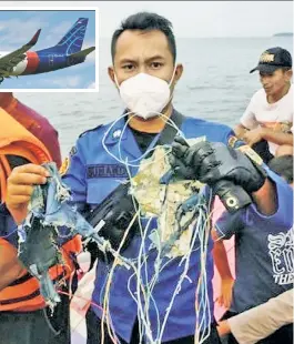  ??  ?? AIR TRAGEDY: Relatives (left) of passengers on the doomed Sriwijaya Air flight gather at the Jakarta airport Saturday. The Boeing 737-500 jet (above) crashed minutes after takeoff. A member of the Indonesian navy rescue and recovery team (right) holds debris from the wreckage found at sea. The domestic flight to Borneo was carrying 62 passengers and crew. There are no reports of survivors. Swirijaya Air had never had a crash before.