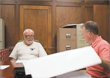  ?? Kevin Myrick/SJ ?? County manager Matt Denton (right) flips through as Commission­er Ray Barber discusses the need to finally install a grinder system for the sewer line coming from the Polk County Jail during the Sept. 8 Public Works commitree meeting.