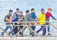  ??  ?? Socorrista­s tailandese­s cargan el cuerpo de una de las víctimas que dejó un naufragio cerca de Phuket. Dos embarcacio­nes se hundieron el pasado jueves.