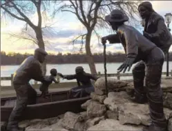  ?? PHOTO BY ANNE BOKMA ?? Above, the Freedom Crossing monument commemorat­ing the Undergroun­d Railroad in Lewiston N.Y. portrays a family being loaded into a boat to make the Niagara River crossing. Top, the suspension bridge near Niagara Falls that Harriet Tubman used to spirit slaves across the border into Canada.