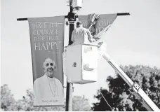  ?? MATT ROURKE, AP ?? A worker hangs banners in Philadelph­ia ahead of Pope Francis’ scheduled visit next week to the United States.