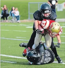  ?? SCOTT WOODLAND SPECIAL TO THE ST. CATHARINES STANDARD ?? Niagara defenders Breton Pearcey, on ground, and Sean Perry bring down a Cambridge ball carrier in OFL Tier 2 bantam action.