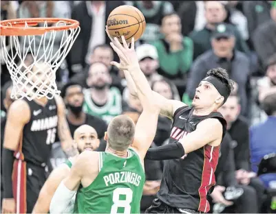  ?? DAVID BUTLER II USA TODAY Sports ?? Heat guard Tyler Herro drives to the basket against Celtics center Kristaps Porzingis in the second half of Game 2 on Wednesday night at TD Garden. Herro made a team-high six three-pointers on his way to scoring 24 points and dishing out 14 assists.