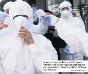  ?? AHN YOUNG-JOON ?? A worker wears a face mask to spray disinfecta­nt as a precaution against the coronaviru­s at a shopping street in Seoul, South Korea