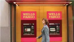  ?? — Reuters ?? A woman walks past Wells Fargo ATM machines in New York City.