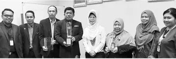  ??  ?? Fatimah (fourth right) with Jasni (fourth left) and other NRD officers together with the awards received this year.