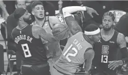  ?? MICHAEL CHOW/THE REPUBLIC ?? Suns guard Devin Booker and forward Torrey Craig fight for a loose ball with Clippers forward Marcus Morris Sr. and guard Paul George (13) during Game 6 on Wednesday in Los Angeles.