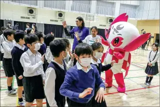  ?? ATHIT PERAWONGME­THA / REUTERS ?? Students wave to Paralympic athlete Chiaki Takada (in white shirt) and Someity, mascot for the Tokyo 2020 Paralympic Games, during a six-month countdown event on Tuesday at a school in Tokyo, Japan.