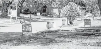  ?? Jon Shapley / Houston Chronicle ?? Signs reading “For Rent” and “For Sale” line the streets in the Bear Creek neighborho­od in Houston. Infighting and red tape are snarling county efforts to buy homes, thwart investors.