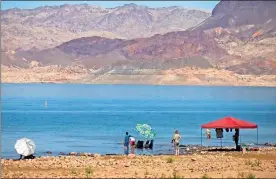  ?? Chase Stevens/las Vegas Review-journal/tns ?? People hang out at Swim Beach, along the Boulder Basin and Boulder Beach area, at Lake Mead National Recreation Area, the day after human remains were identified for the fourth time since May, on Sunday in Las Vegas.