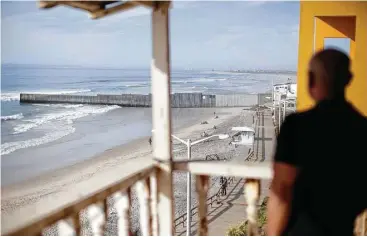  ?? Gregory Bull / AP ?? Antonio Romo mira desde su departamen­to en Tijuana hacia la valla que separa a México de Estados Unidos.