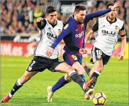  ??  ?? Valencia's Portuguese midfielder Manuel Guedes (L) vies with Barcelona's Lionel Messi during the Spanish league football match at Mestalla stadium.