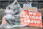 ??  ?? Protesters brave heavy rain as they demonstrat­e outside Parliament