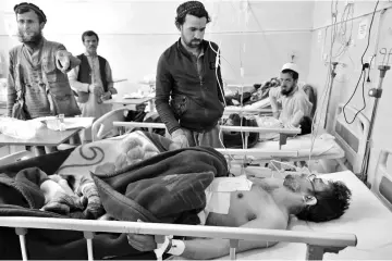  ??  ?? Afghan victims receive medical treatment at a hospital following a suicide attack on a private constructi­on company in Jalalabad. — AFP photo