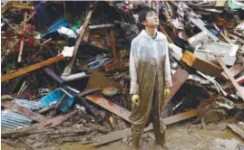  ??  ?? GIVING AID
... A local resident reacts while helping to remove debris at his friend’s home that was effected by floods caused by heavy rain in Hitoyoshi, Kumamoto prefecture, southern Japan yesterday. More than 50 people are feared dead in the floods. – REUTERSPIX