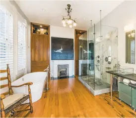  ?? Olga Soboleva/Vanguard Properties ?? The master bathroom blends contempora­ry designs like a walk-in shower and glass sinks with period details, including a ceiling medallion.