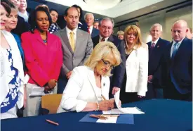  ??  ?? PHOENIX: In this June 17, 2013, file photo, Arizona Gov Jan Brewer signs the Medicaid expansion law in Phoenix.