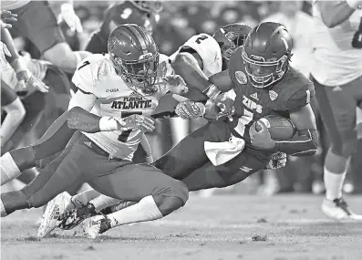  ?? Jim Rassol/Sun Sentinel/TNS ?? Akron quarterbac­k Kato Nelson (1) gains a few tough yards as Florida Atlantic linebacker­s Azeez Al-Shaair (2) and Rashad Smith (7) close in for the tackle Tuesday in the Cheribundi Tart Cherry Boca Raton Bowl at FAU Football Stadium in Boca Raton, Fla.