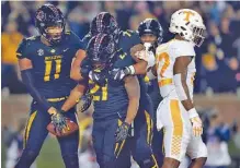  ?? THE ASSOCIATED PRESS ?? Missouri’s Ish Witter (21) is congratula­ted by teammates Kendall Blanton (11) and Kevin Pendleton (71) as Tennessee defensive back Micah Abernathy walks past after Witter ran for a touchdown during the first half of the Tigers’ 50-17 win Saturday night.