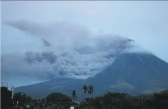  ?? Earl Recamunda / Associated Press ?? The cloud-shrouded Mayon volcano spews ash as lava continues to flow down the slopes near the top, as seen from Legazpi city, Albay province, around 210 miles southeast of Manila.