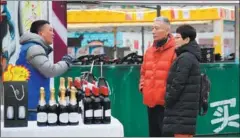  ?? LI YIBO / XINHUA ?? Residents in Xi’an, Shaanxi province, shop for foreign wines imported via the China-Europe freight rail links in January.