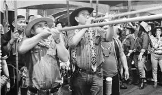  ??  ?? Abdul Karim (second left) and Miro (left) show their skills with blowpipes at the festival.