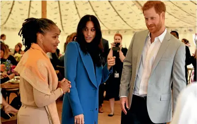  ?? AP ?? Meghan, the Duchess of Sussex, centre, talks to her mother Doria Ragland, with Prince Harry at right, as they attend a reception for the cookbook Together ,at Kensington Palace, in London.