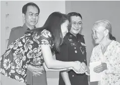  ??  ?? Dinamicaya­nti (left) presents a gift to single mother Ta’siah Ibis, 76, from Kampung Bedil in Kanowit. From second left are Petrus and Daniel.