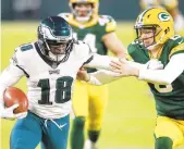  ?? MATTLUDTKE/AP ?? Eagles rookie Jalen Reagor gets past Packers punter J.K. Scott for a touchdown Sunday in Green Bay. The Eagles’first-round draft choice, who has missed a lot of time with injuries, has just 20 catches for 256 yards and a touchdown as a receiver.