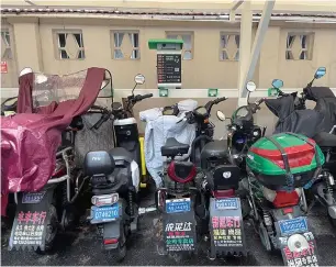  ?? ?? Despite proximity to a public charging station in Shanghai’s Hongkou District, many electric bikes remain unconnecte­d. — Yang Jian
