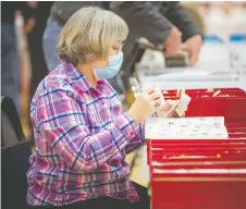  ?? DAX MELMER ?? Janice White, from Mississaug­a, browses through catalogues of stamps at the WINPEX Stamp Show at the Caboto Club on Saturday.