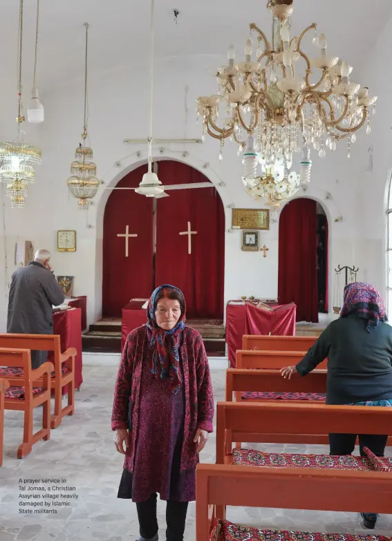  ??  ?? A prayer service in
Tal Jomaa, a Christian Assyrian village heavily damaged by Islamic State militants