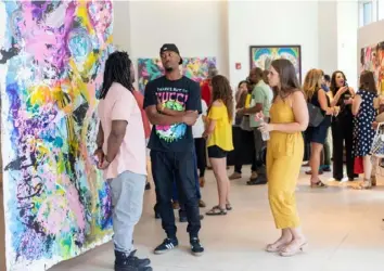  ?? Karen Plate ?? Artist Baron Batch, left, speaks to attendees at the launch event for “Love is #Free.”