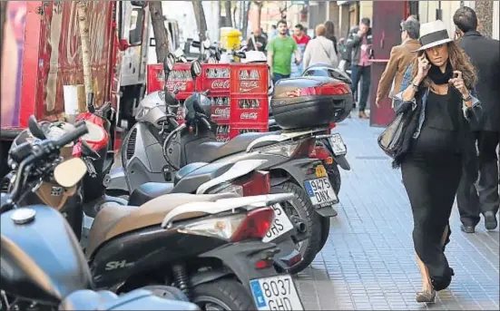  ?? MARC ARIAS ?? Las motos comparten espacio con la carga y descarga, las bicicletas y los legítimos propietari­os de las aceras: los peatones