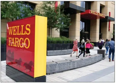  ?? (AP) ?? People pass a Wells Fargo building in downtown Minneapoli­s in this 2019 file photo. The bank said Thursday that it has fired as many as 125 workers for defrauding the Small Business Administra­tion.