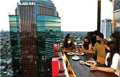  ?? ROBERTUS RIZKY/JAWA POS ?? MENINGKAT: Pengunjung menikmati kuliner di skylounge di Goldvitel Hotel, Jalan Basuki Rahmat, Surabaya. Okupansi hotel mulai mengalami lonjakan pasca penurunan level PPKM.