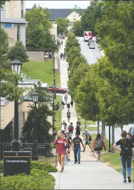  ?? NWA Democrat-Gazette/SPENCER TIREY ?? University of Arkansas students make their way to classes Friday on Dickson Street in Fayettevil­le.