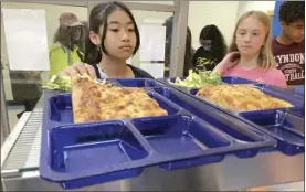  ?? AP photo ?? Students get lunch of homemade pizza and caesar salad at the Albert D. Lawton Intermedia­te School, in Essex Junction, Vt., on Thursday. The pandemic-era federal aid that made school meals available for free to all public school students — regardless of family income levels — is ending, raising fears about the effects in the upcoming school year for families already struggling with rising food and fuel costs.