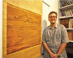  ??  ?? Shawn Eichmann, curator of Asian art for the Honolulu Museum of Art, poses next to a 16th century Korean painting. —AP