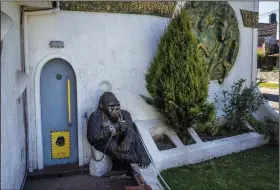  ?? ?? A cement sculpture of a gorilla named Pepe with a cup of mate is chained to a wall Nov. 1 to prevent it from being snatched in San Miguel, Argentina.