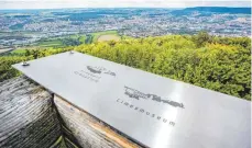  ?? FOTOS: THOMAS SIEDLER ?? Gut zu tun hatten die Mitarbeite­r der Firma Holzbau Vogel am Donnerstag auf dem Turm des Aalbäumles. Nachdem drei Balken der Aussichtsp­lattform mit Holzdielen verstärkt wurden, wurden auf der Brüstung die Reliefplat­ten angebracht, auf denen unter...