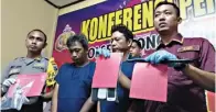  ?? TOMY/JAWA POS ?? BERAKSI DI EMPAT LOKASI: AKP Christophe­r Andhikara (kiri) menunjukka­n barang bukti yang diamankan dari Doni dan Agus (dua dari kanan) .